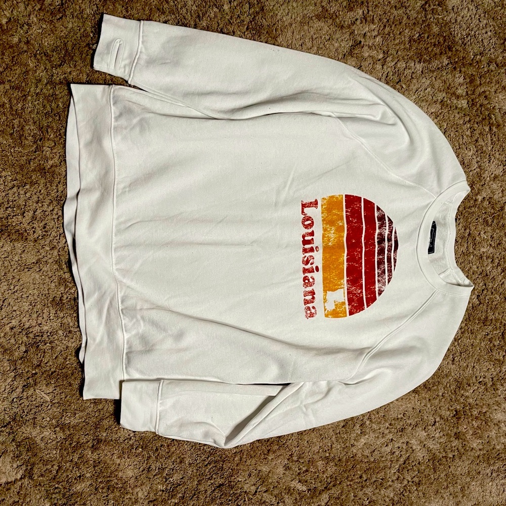 White sweatshirt with a sunset saying Louisiana